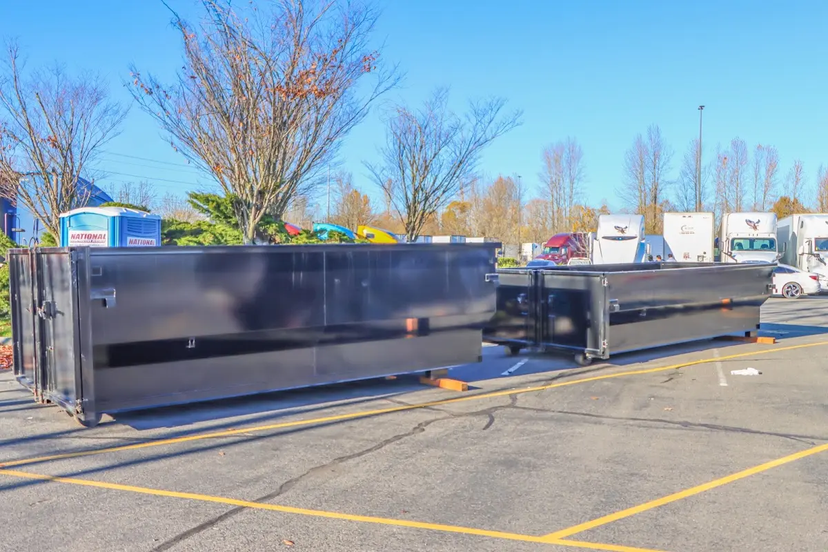 Professional dumpster rental service with roll-off container on residential driveway in Lakeland Village